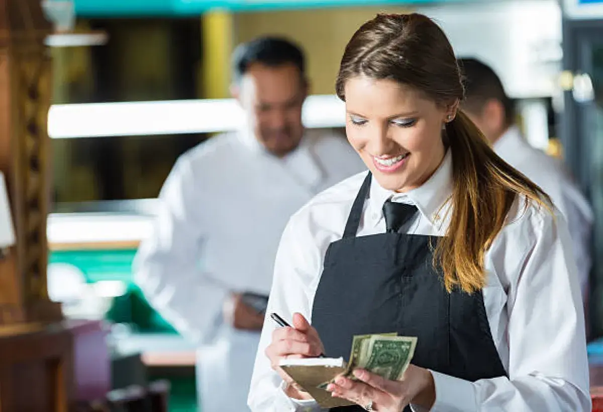 American restaurant server calculating a customer’s tip.