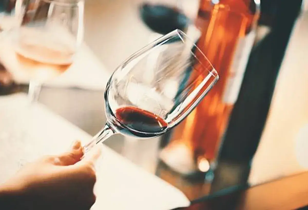 hand swirling red wine glass during tasting