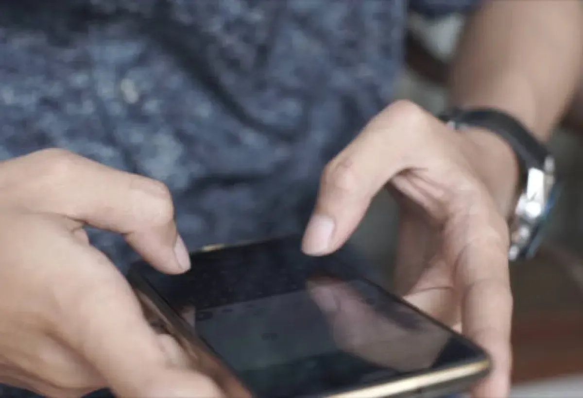 Hands typing rapidly on a smartphone screen