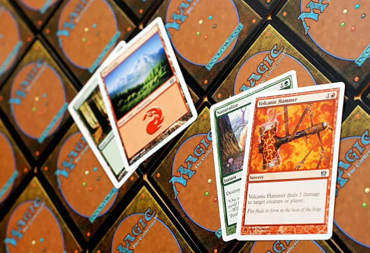 Close-up of trading cards and a sticker album spread on a table