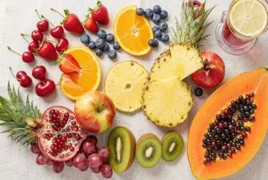 A vibrant flat lay of cherries, berries, citrus, pineapple, and pomegranate, symbolizing delicious, anti-inflammatory fruits for arthritis relief.