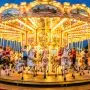 A colorful, spinning vintage carousel with detailed horses and bright lights